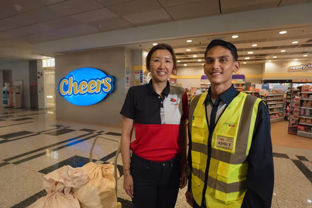 Neo Su Yin (SingPost GCOO) with Mohd Asyraf Bin Ab Rahim (Delivery staff) outside a Cheers outlet